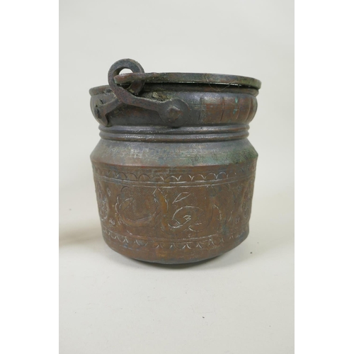 224 - A middle eastern brass coffee pot with chased decoration, a smaller white metal coffee pot and an an... 