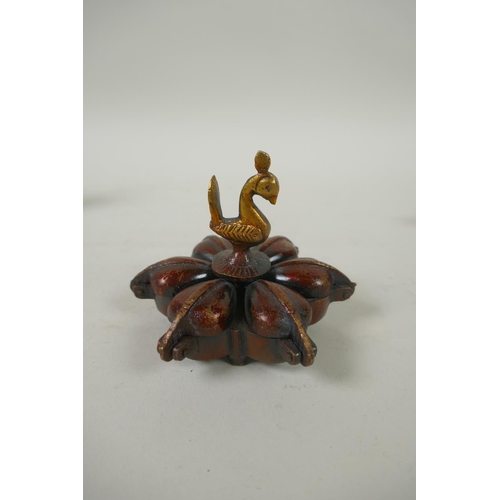 226 - An Indian bronze tikka box, together with a bronze conch incense holder, a miniature bronze ganesh a... 