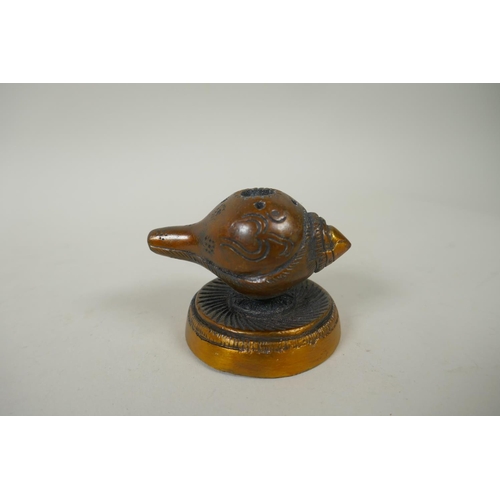 226 - An Indian bronze tikka box, together with a bronze conch incense holder, a miniature bronze ganesh a... 