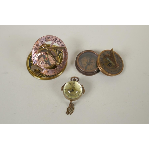 242 - A brass bound glass ball pendant clock, and a reproduction Stanley compass, and another, largest 8cm... 