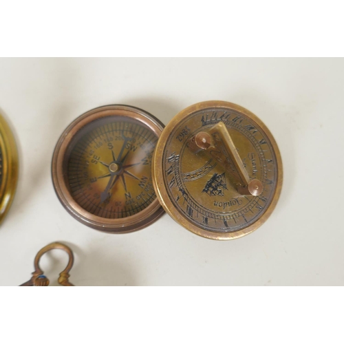 242 - A brass bound glass ball pendant clock, and a reproduction Stanley compass, and another, largest 8cm... 