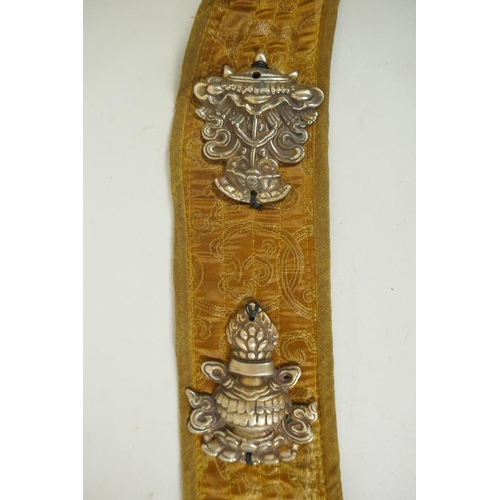 270 - A Tibetan silk sash affixed with metal mounts depicting the eight Buddhist treasures, 74cm long