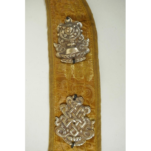 270 - A Tibetan silk sash affixed with metal mounts depicting the eight Buddhist treasures, 74cm long