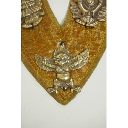 270 - A Tibetan silk sash affixed with metal mounts depicting the eight Buddhist treasures, 74cm long