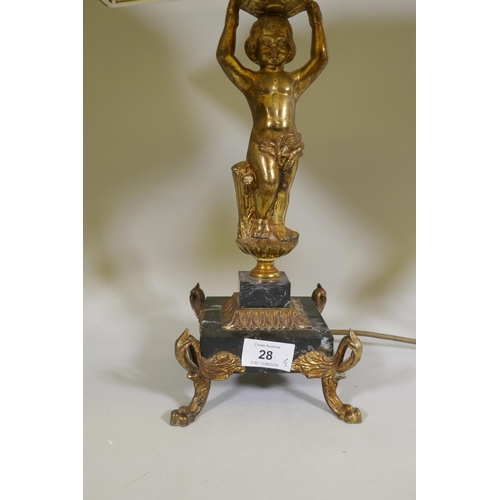 28 - A gilt brass table lamp in the form of putto, on a marble base with paw feet, (one requires re-fixin... 