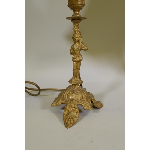 28 - A gilt brass table lamp in the form of putto, on a marble base with paw feet, (one requires re-fixin... 