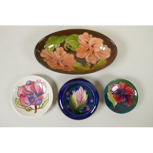 296 - Three Moorcroft pin dishes decorated with hibiscus, pink magnolia, and berry and leaf, and a hibiscu... 