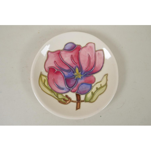 296 - Three Moorcroft pin dishes decorated with hibiscus, pink magnolia, and berry and leaf, and a hibiscu... 