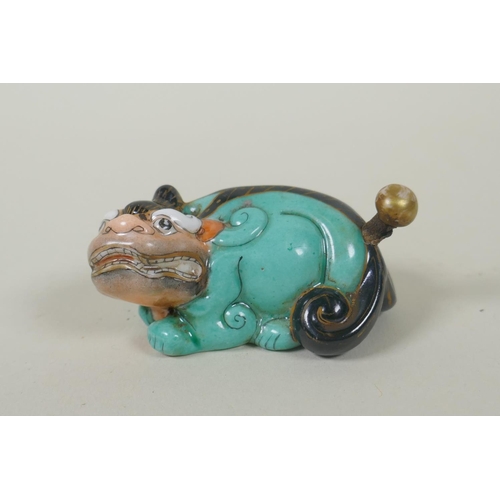 35 - A Chinese polychrome porcelain snuff bottle in the form of a kylin, Qianlong 4 character mark to bas... 