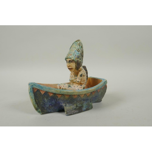 39 - An Amanda Popham (b.1954) studio pottery figure wearing a fish head riding in a boat, signed and dat... 