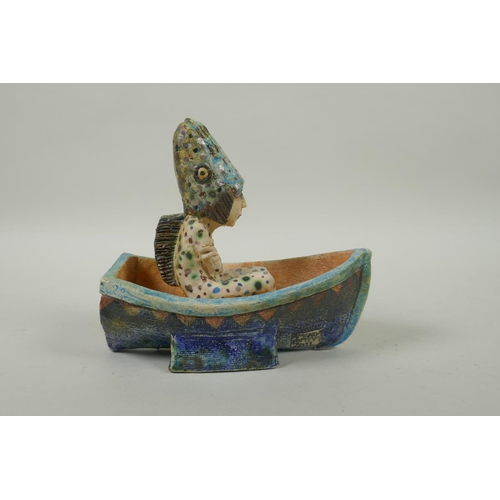 39 - An Amanda Popham (b.1954) studio pottery figure wearing a fish head riding in a boat, signed and dat... 