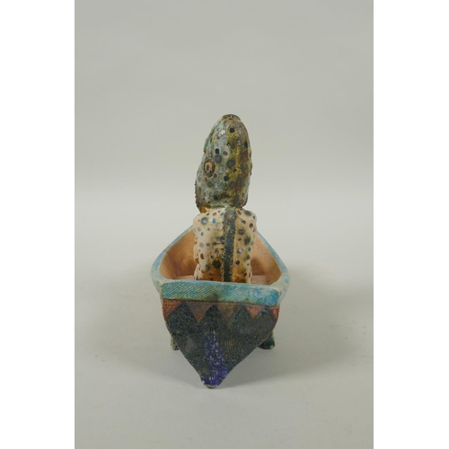 39 - An Amanda Popham (b.1954) studio pottery figure wearing a fish head riding in a boat, signed and dat... 