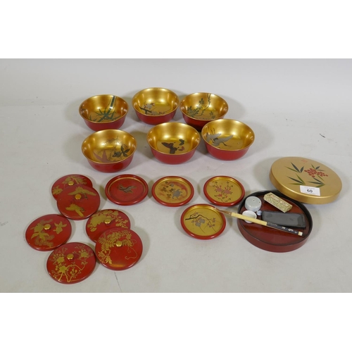 60 - A set of Oriental lacquered and gilt bowls with hand painted decoration, 12cm diameter, coasters and... 