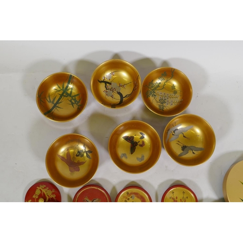 60 - A set of Oriental lacquered and gilt bowls with hand painted decoration, 12cm diameter, coasters and... 