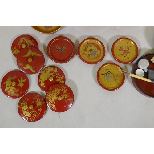 60 - A set of Oriental lacquered and gilt bowls with hand painted decoration, 12cm diameter, coasters and... 