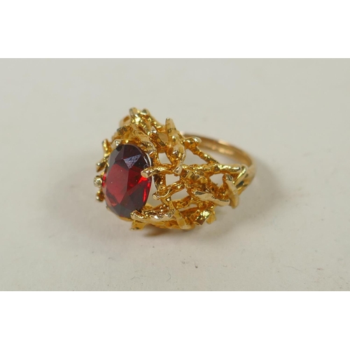 604 - A yellow metal garnet set twig ring, tests as gold, marks rubbed, probably 14ct, 6.4g gross, size M