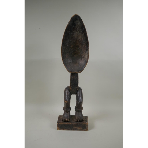 69 - An African Ivory Coast carved wood Dan peoples ceremonial Wakemia ladle, 57cm high