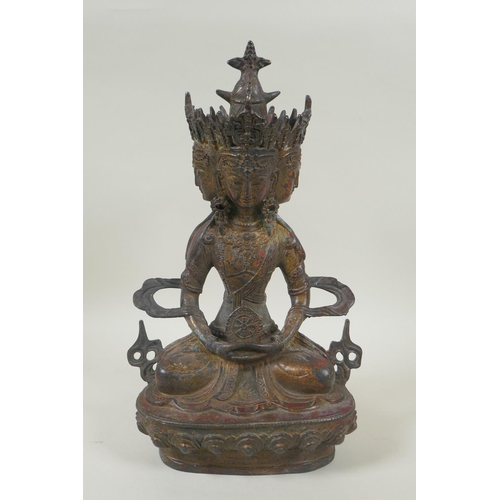 81 - A Sino Tibetan bronze figure of a multi faced deity, with the remnants of gilt and red lacquer patin... 