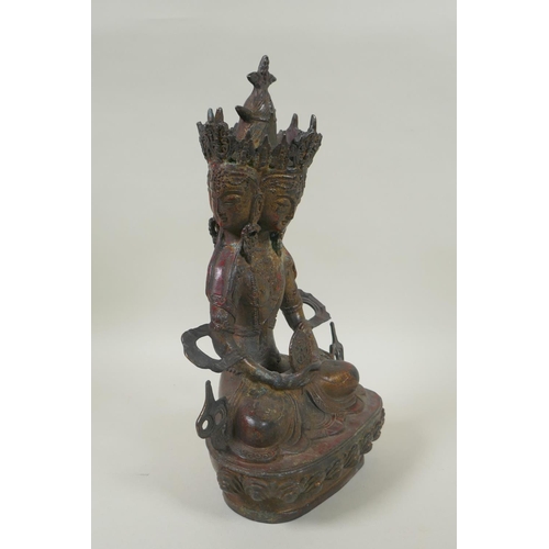 81 - A Sino Tibetan bronze figure of a multi faced deity, with the remnants of gilt and red lacquer patin... 