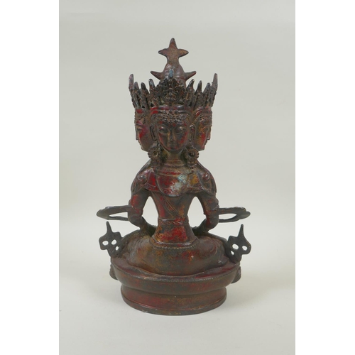 81 - A Sino Tibetan bronze figure of a multi faced deity, with the remnants of gilt and red lacquer patin... 