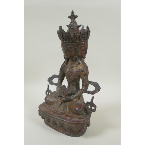 81 - A Sino Tibetan bronze figure of a multi faced deity, with the remnants of gilt and red lacquer patin... 