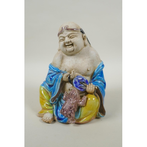 90 - A Chinese porcelain figure of an immortal with Sancai glazed robes, 17cm high