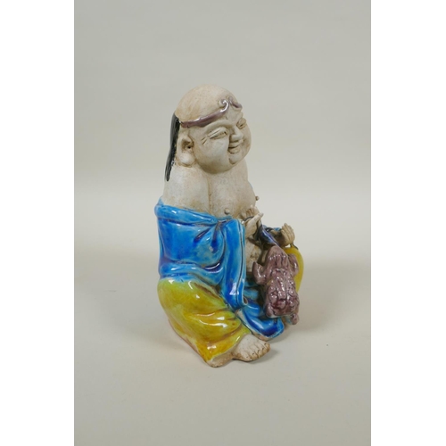 90 - A Chinese porcelain figure of an immortal with Sancai glazed robes, 17cm high