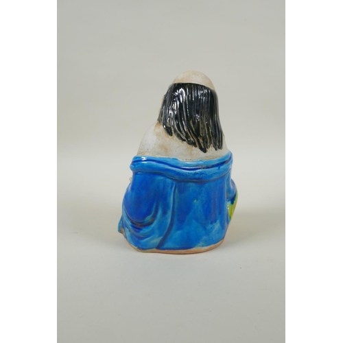 90 - A Chinese porcelain figure of an immortal with Sancai glazed robes, 17cm high