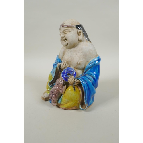 90 - A Chinese porcelain figure of an immortal with Sancai glazed robes, 17cm high