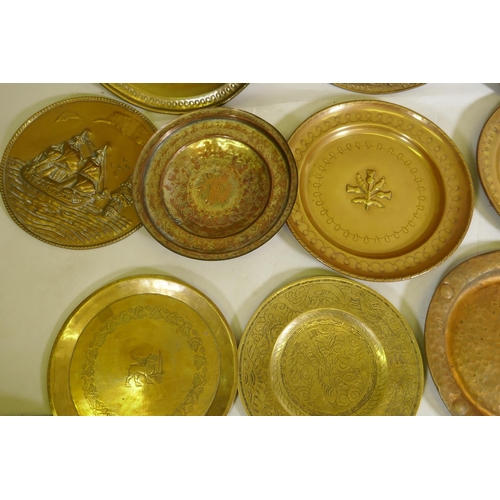 96 - A quantity of copper and brass wall plaques and trays, largest 46cm diameter