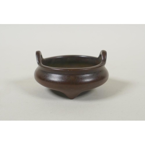 99 - A Chinese miniature bronze censer with phoenix eye handles and tripod supports, impressed seal mark ... 