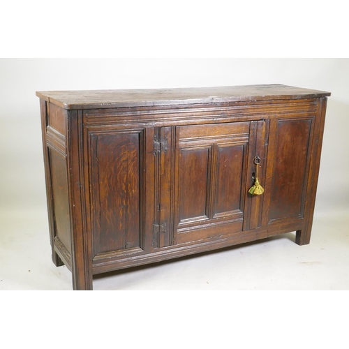 1093 - An C18th oak side cabinet with single panelled door cupboard and moulded details, 138 x 43 x 85cm, r... 