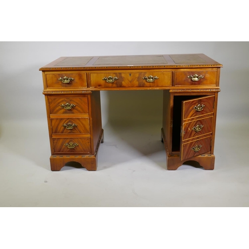 1155 - A Georgian style mahogany pedestal desk with inset leather top, six drawers and cupboard, raised on ... 