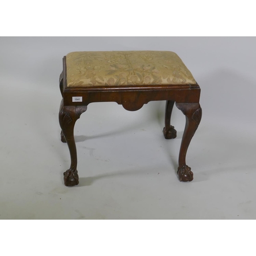 1182 - A Georgian style walnut foot stool raised on carved cabriole supports with claw and ball feet, 57 x ... 