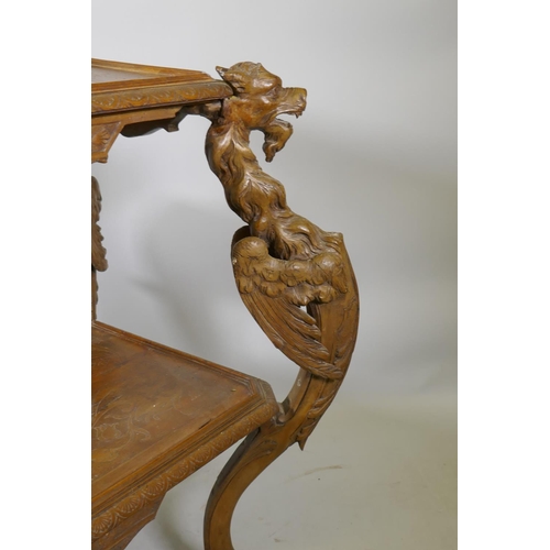 1238 - A C19th Continental walnut two tier etagere, with carved and incised decoration, raised on four wing... 