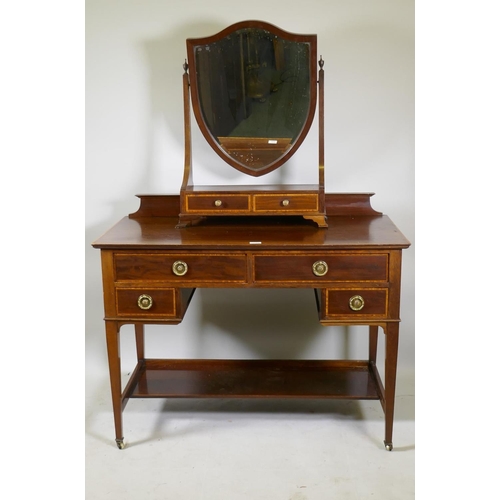 1147 - A mahogany five drawer kneehole dressing table with satinwood banded inlay, raised on tapering suppo... 