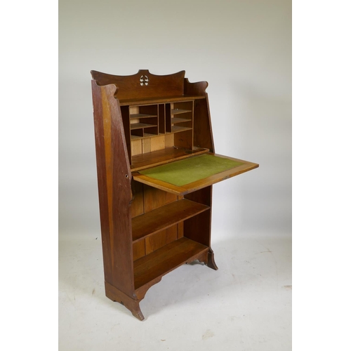 1154 - An Arts & Crafts oak hall/student's bureau, the fall front with fitted interior over two open sh... 