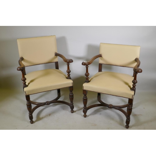 1216 - A pair of Continental oak show frame open arm chairs with leather upholstery and studded decoration,... 