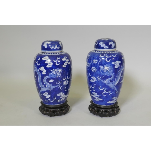 1 - A pair of antique Chinese blue and white dragon jars with covers, KangXi four character mark to base... 