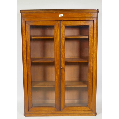 1003 - A Victorian mahogany bookcase with two glazed doors and canted corners, raised on a plinth base, 82 ... 