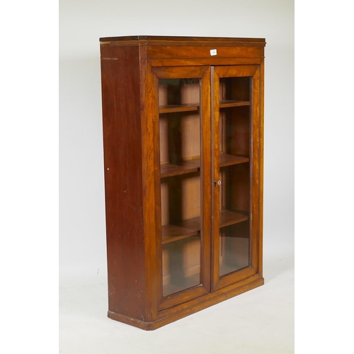 1003 - A Victorian mahogany bookcase with two glazed doors and canted corners, raised on a plinth base, 82 ... 