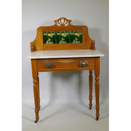 1011 - An Edwardian satin walnut single drawer wash stand with inset tiled back and marble top, raised on t... 