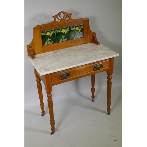 1011 - An Edwardian satin walnut single drawer wash stand with inset tiled back and marble top, raised on t... 