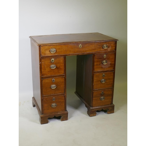 1028 - A Georgian mahogany kneehole desk, the seven drawers with cock beaded detail and original brass plat... 