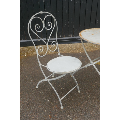 1033 - A French painted iron three piece bistro set, table 60cm diameter, 67cm high