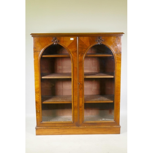 1038 - A good Victorian mahogany bookcase with two arched glazed doors with carved fleur-de-lys details, ra... 