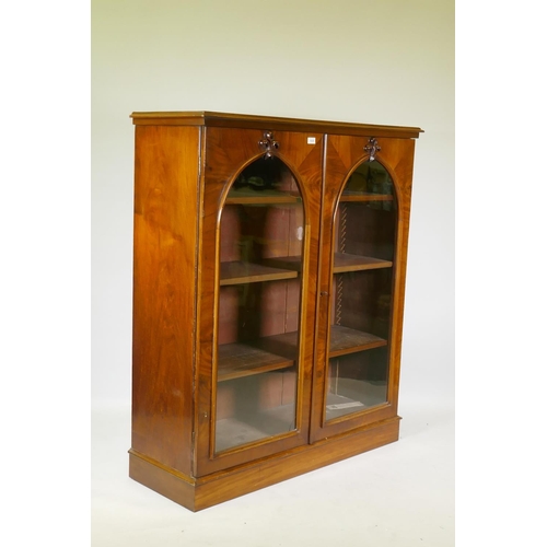 1038 - A good Victorian mahogany bookcase with two arched glazed doors with carved fleur-de-lys details, ra... 