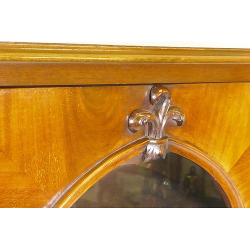 1038 - A good Victorian mahogany bookcase with two arched glazed doors with carved fleur-de-lys details, ra... 