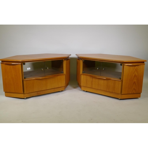 1047 - A pair of teak corner units with tinted glass doors over a single drawer, flanked by cupboards, 104 ... 