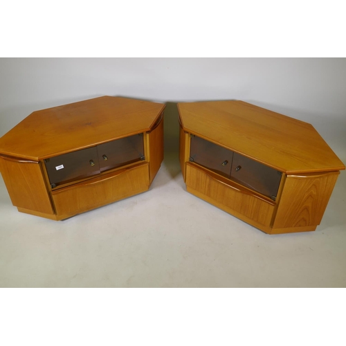 1047 - A pair of teak corner units with tinted glass doors over a single drawer, flanked by cupboards, 104 ... 